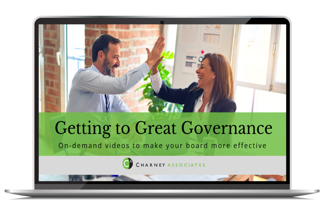 Laptop screen with image of two professionals, one man and one woman, giving each other a high five. The banner across the screen says Getting to Great Governance: On-demand videos to help your board be more effective