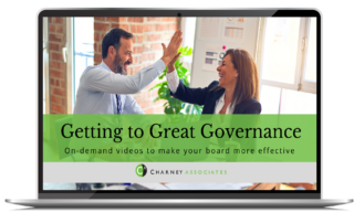 Laptop screen with image of two professionals, one man and one woman, giving each other a high five. The banner across the screen says Getting to Great Governance: On-demand videos to help your board be more effective